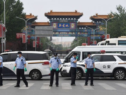 TOPSHOT - Chinese police guard the entrance to the closed Xinfadi market in Beijing on Jun