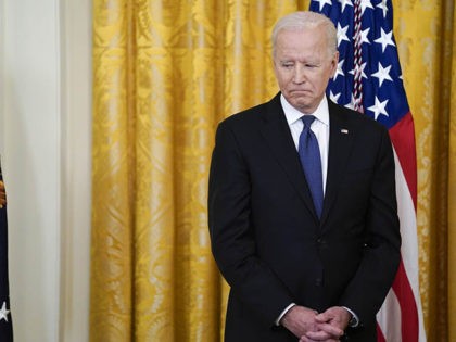 President Joe Biden looks towards the table with the COVID-19 Hate Crimes Act on it before the signing in the East Room of the White House, Thursday, May 20, 2021, in Washington. (AP Photo/Evan Vucci)