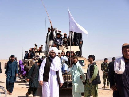 In this photo taken on June 17, 2018, Afghan Taliban militants and residents stand on a ar