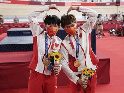 Aug 2, 2021; Tokyo, Japan; Tianshi Zhong (CHN) and Shanju Bao (CHN) celebrate their gold medal in the women's team sprint during the Tokyo 2020 Olympic Summer Games at Izu Velodrome. Mandatory Credit: Andrew P. Scott-USA TODAY Sports