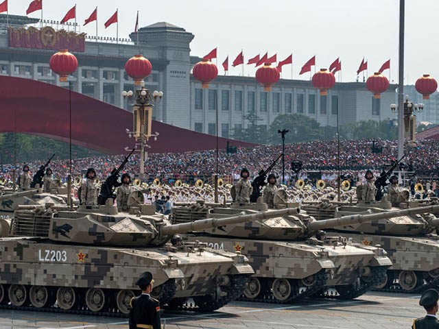BEIJING, CHINA - OCTOBER 01: Chinese soldiers sit atop tanks as they drive in a parade to
