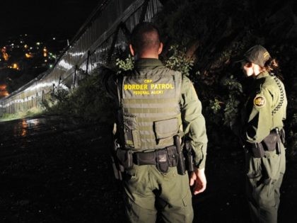 US Border Patrol agents Colleen Agle (R) and Richard Funke (L) patrol along the border fence between Arizona and Mexico at the town of Nogales on July 28, 2010. A federal judge blocked the most controversial parts of Arizona's new immigration law, barring police from checking the immigrant status of …