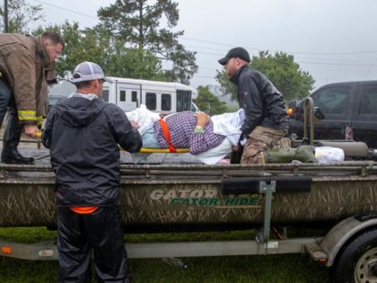 Members of the Cajun Navy and emergency workers place a nursing home patient on a boat during the evacuation of a nursing home due to rising flood waters in Lumberton, North Carolina, on September 15, 2018 in the wake of Hurricane Florence. - Besides federal and state emergency crews, rescuers …