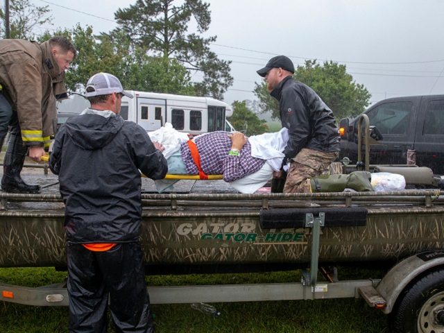 Members of the Cajun Navy and emergency workers place a nursing home patient on a boat dur