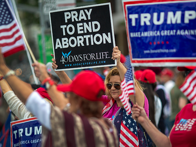 A woman holds an anti-abortion placard as supporters of President Donald Trump rally outside the Wilshire Federal Building on June 2, 2019 in Los Angeles, California. The rally was billed as the first of several grassroots rallies in Los Angeles for the re-election of Trump in 2020. (Photo by David …