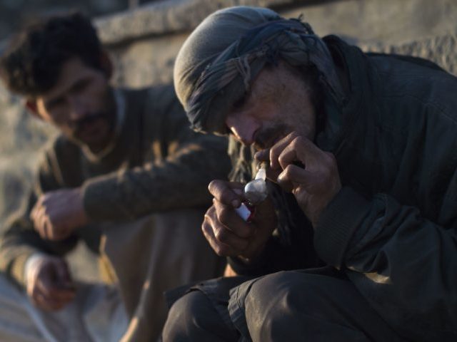 Addicts smoke opium along a roadside in Kabul on October 23, 2019. (Photo by WAKIL KOHSAR / AFP) (Photo by WAKIL KOHSAR/AFP via Getty Images)