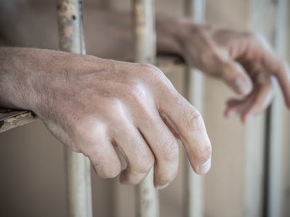 Close up of prisoner hands in a jail.