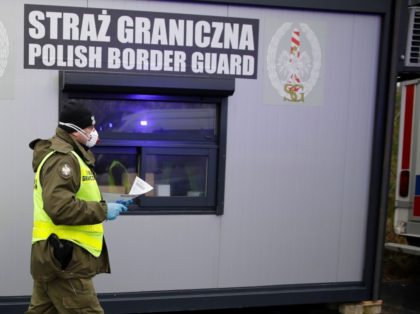 A picture taken on March 9, 2020 on the Polish side shows Polish border guards and medical staff, with protective clothing, walking during sanitary checks on drivers at Jedrzychowice border crossing, between Poland and Germany, in a measure to protect against the spread of the novel coronavirus. - The introduction …