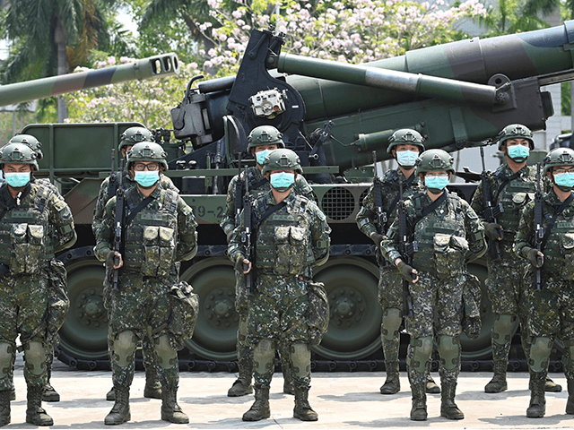Soldiers wearing face masks amid the COVID-19 coronavirus pandemic stand in formation in front of a US-made M110A2 self-propelled howitzer during Taiwan President Tsai Ing-wen's visit to a military base in Tainan, southern Taiwan, on April 9, 2020. - Taiwan currently has just 375 confirmed Covid-19 patients and five deaths …