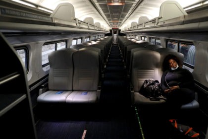 BALTIMORE, MARYLAND - APRIL 09: A lone passenger sleeps in an otherwise empty Amtrak car as the train pulls into Penn Station on April 9, 2020 in Baltimore, Maryland. Amtrak and commuter trains have cut daily routes amid the coronavirus (COVID-19) pandemic. (Photo by Rob Carr/Getty Images)