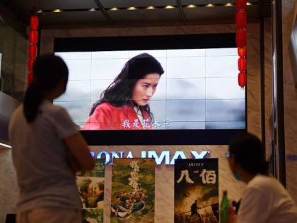 People watch a trailer for the Disney movie "Mulan" at a theater in Beijing on September 9, 2020. - Disney's "Mulan" remake is facing fresh boycott calls after it emerged some of the blockbuster's scenes were filmed in China's Xinjiang, where widespread rights abuses against the region's Muslim population have …