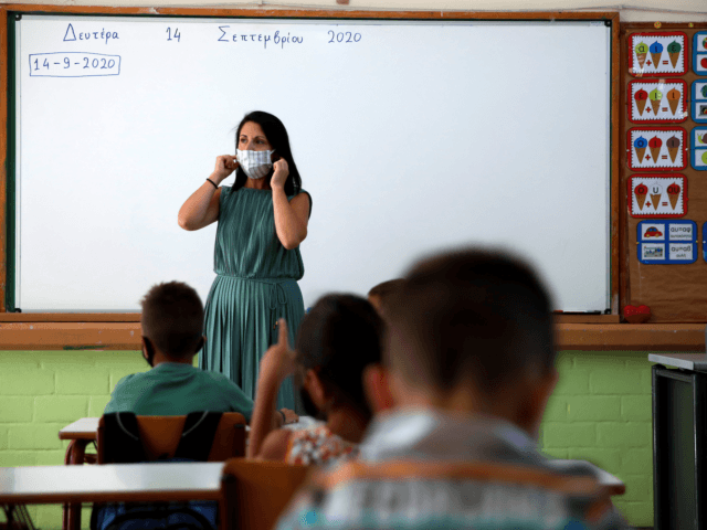 A teacher explains to pupils how to use the face masks at a primary school on the first day of class of the new academic year in Athens, on September 14, 2020, amid the crisis linked with the covid-19 pandemic caused by the novel coronavirus. - Schools open on Monday …