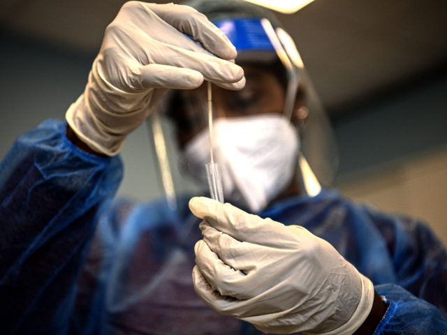 TOPSHOT - A medical worker puts a swab in a tube after performing an antigen test for Covi