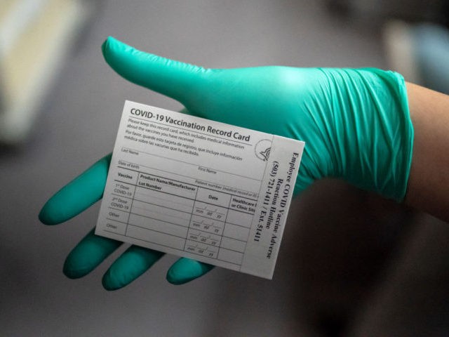 PORTLAND, OR - DECEMBER 16: A healthcare worker displays a COVID-19 vaccine record card at