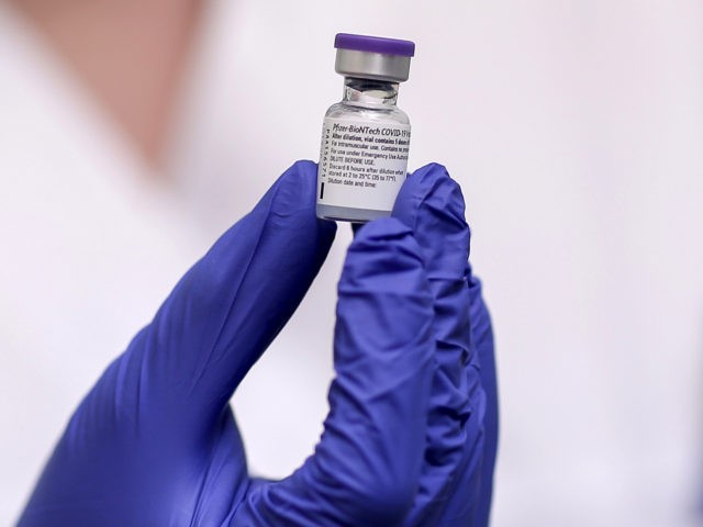 A nurse holds a vial of the Pfizer-BioNTech vaccine at the Attikon University Hospital in