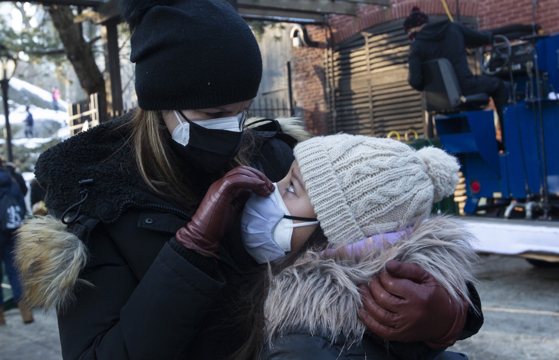 A woman adjusts a child's mask after they after they ice-skated on the last day at the Wollman ice skating rink now closed in Central Park New York on February 21, 2021. - The City of New York was to end today the contracts that allow the Trump Organization to manage several attractions such as the Wollman and Lasker Rinks, following the violent outburst of violence at the U.S. Capitol, but after New Yorkers complained about the closure of a safe outdoor exercise facility during the pandemic, mayor Bill De Blasio issued this statement: New York City kids deserve all the time on the ice they can get this year, the Wollman and Lasker rinks will stay open under current management for the few weeks left in this season. But make no mistake, we will not be doing business with the Trump Organization going forward. Inciting an insurrection will never be forgotten or forgiven. (Photo by Kena Betancur / AFP) (Photo by KENA BETANCUR/AFP via Getty Images)