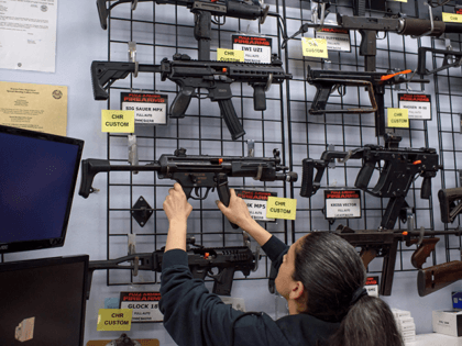 Employee Gorety Mejia takes down a HK MP5 for a customer at Full Armor Firearms store in H