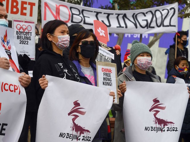 Activists including members of the local Hong Kong, Tibetan and Uyghur communities hold up banners and placards in Melbourne on June 23, 2021, calling on the Australian government to boycott the 2022 Beijing Winter Olympics over China's human rights record. (Photo by William WEST / AFP) (Photo by WILLIAM WEST/AFP …