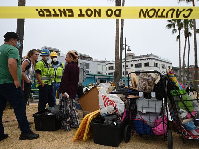 Dixie Moore (R) talks with representatives from St Joseph Center Homeless Services who will help her move from her tent encampment along the Venice Beach Boardwalk, to short-term housing in a nearby hotel July 2, 2021 in Los Angeles, California, as city sanitation workers prepare to clear the area ahead …