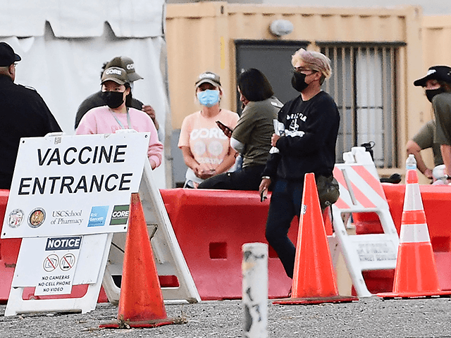 People wearing facemasks outdoors are seen at a Covid-19 vaccine site in Los Angeles, Cali