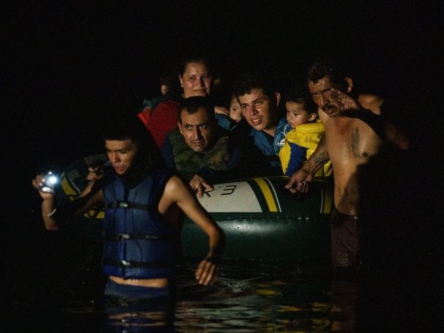 TOPSHOT - Migrants are pulled across the Rio Grande by human smugglers while crossing the US-Mexico border on rafts in Roma, Texas on July 8, 2021. - Republican lawmakers have slammed Biden for reversing Trump programs, including his "remain in Mexico" policy, which had forced thousands of asylum seekers from …