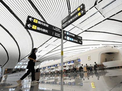 A passenger pushes her luggage to the check-in area at Beijing's Daxing International Airp