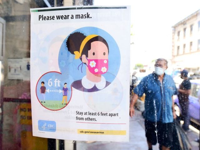 A storefront sign reminds people to wear a facemask on July 19, 2021 in Los Angeles, California. - A continuing resurgence in the Covid-19 pandemic is seeing local rates rise and hospitalizations skyrocket amid a new face-covering mandate that went into effect over the weekend. (Photo by Frederic J. BROWN …