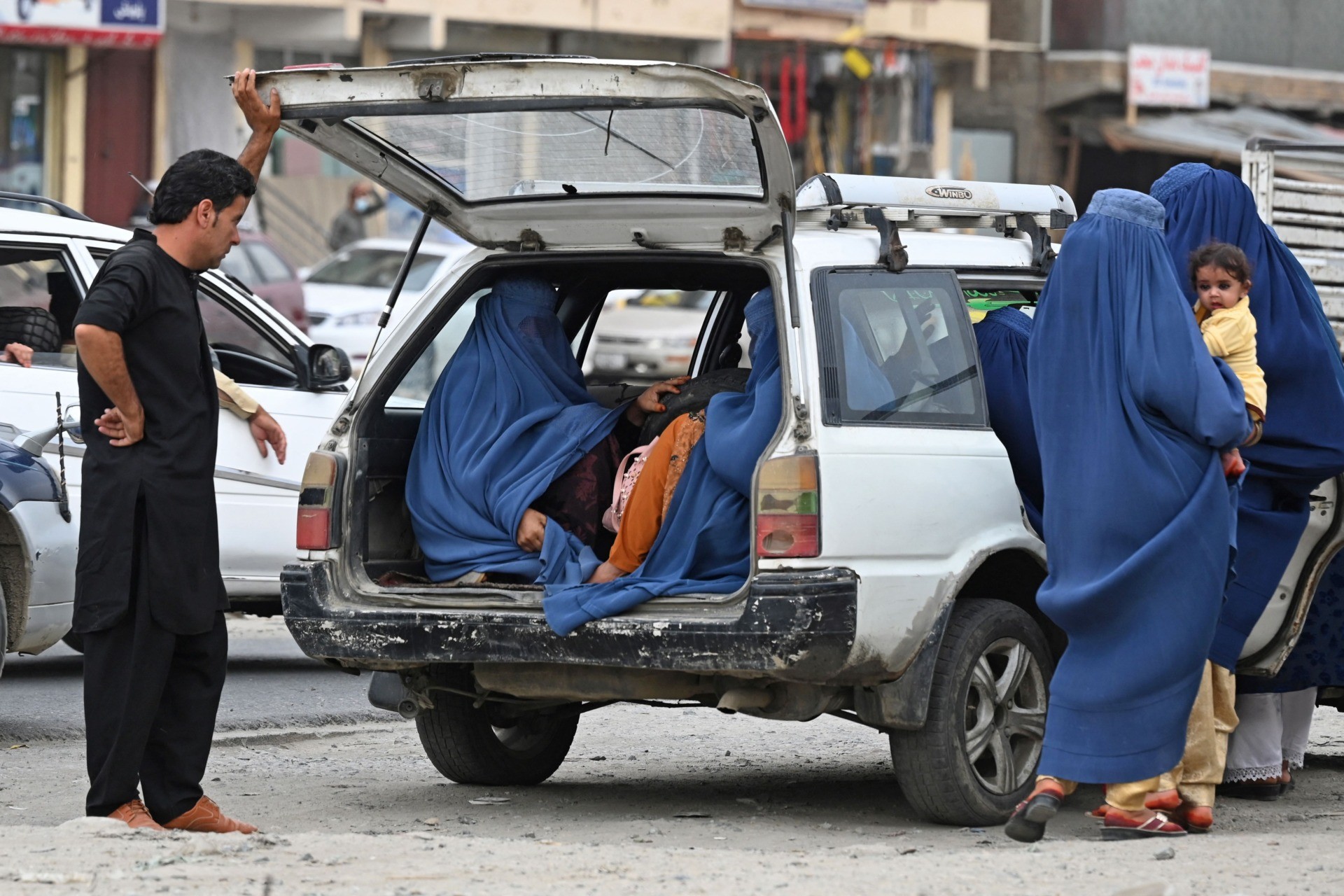 Women wearing a burqa get into a local taxi in Kabul on July 31, 2021. (Photo by SAJJAD HUSSAIN / AFP) (Photo by SAJJAD HUSSAIN/AFP via Getty Images)