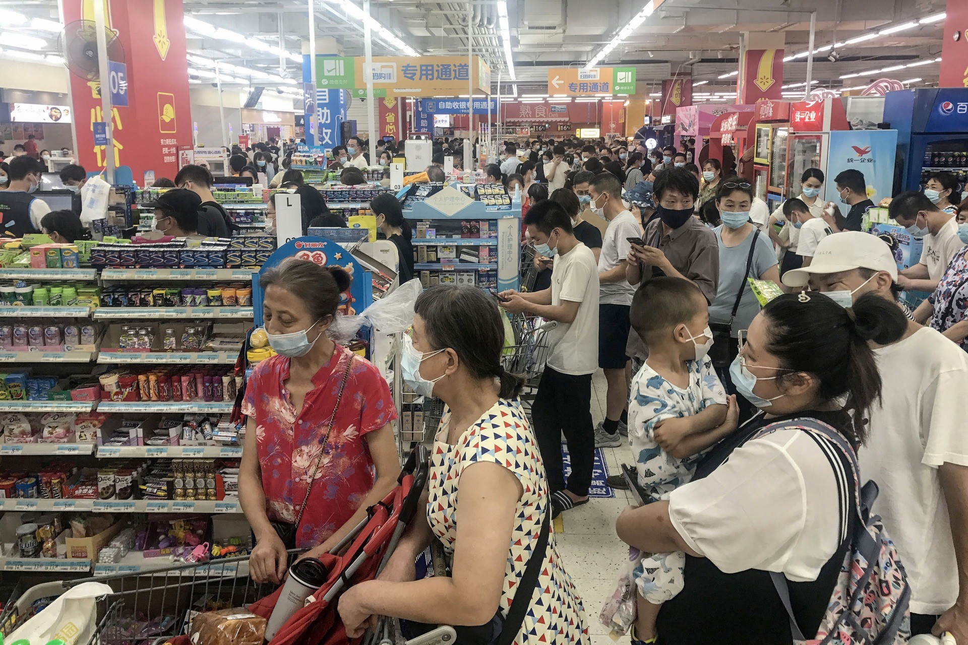This photo taken on August 2, 2021 shows people buying items at a supermarket in Wuhan, in China's central Hubei province, as authorities said they would test its entire population for Covid-19 after the central Chinese city where the coronavirus emerged reported its first local infections in more than a year. - China OUT (Photo by STR / AFP) / China OUT (Photo by STR/AFP via Getty Images)