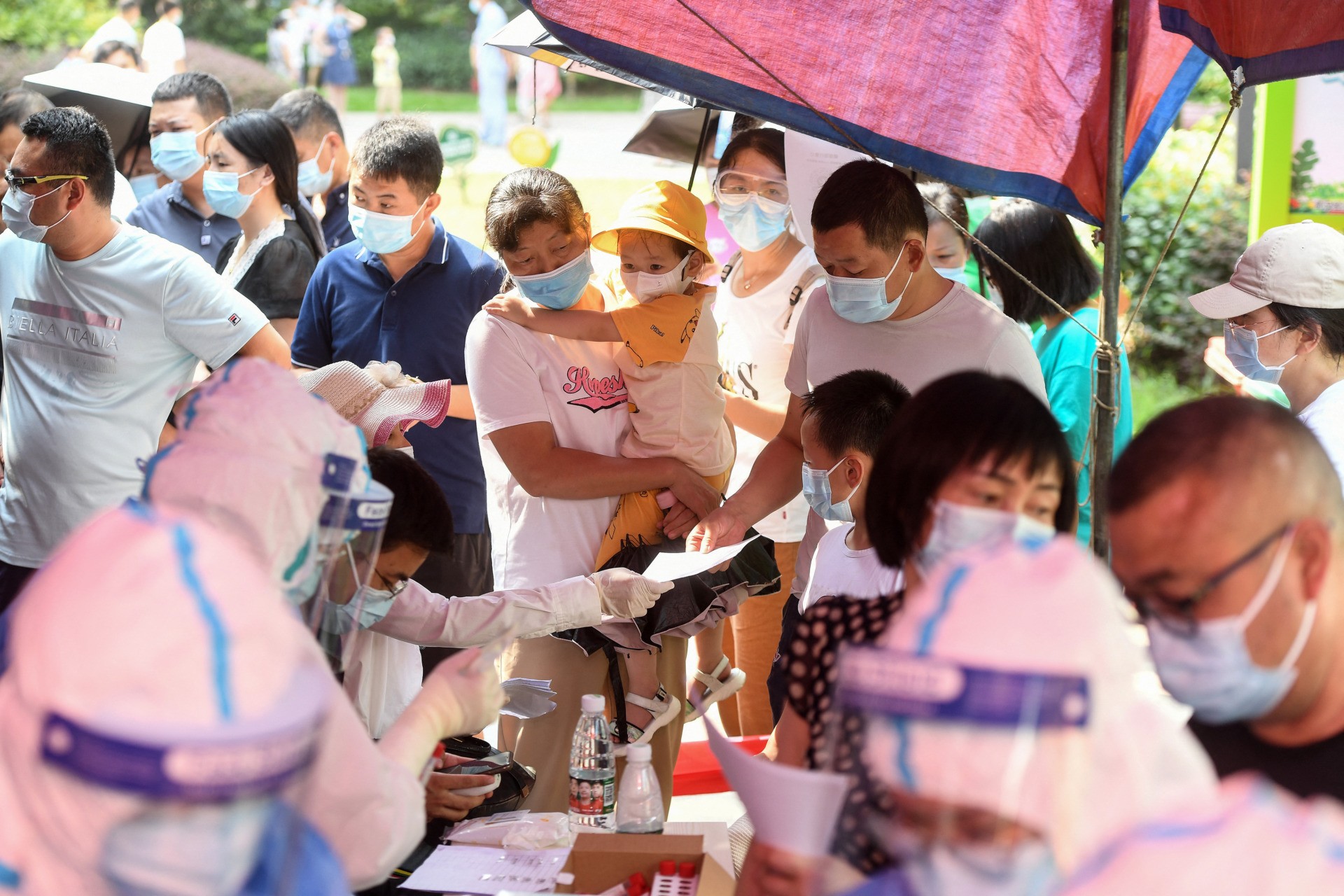 TOPSHOT - Residents queue to take nucleic acid tests for the coronavirus in Wuhan in China's central Hubei province on August 3, 2021, as the city tests its entire population for Covid-19. - China OUT (Photo by STR / AFP) / China OUT (Photo by STR/AFP via Getty Images)