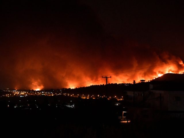 This picture taken on August 5, 2021 shows flames rising from a fire spreading around Kapandriti, on the outskirts of Athens. - Firefighters were battling a series of raging blazes in sweltering heat on August 5, 2021, in western and eastern Greece, and near Athens where a fire that had …