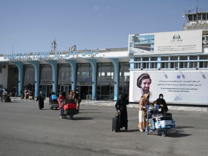 Afghan passengers carry their belongings as they come out from the domestic terminal, at the Kabul airport in Kabul on August 8, 2021. (Photo by WAKIL KOHSAR / AFP) (Photo by WAKIL KOHSAR/AFP via Getty Images)