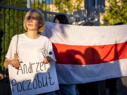 Activists and members of the Belarusian diaspora in Poland hold placards and former national red and white flags of Belarus as they take part in a rally in front of the Belarussian Embassy in Warsaw, Poland, on August 8, 2021. - The rally marks the first anniversary of anti-Lukashenko protests …