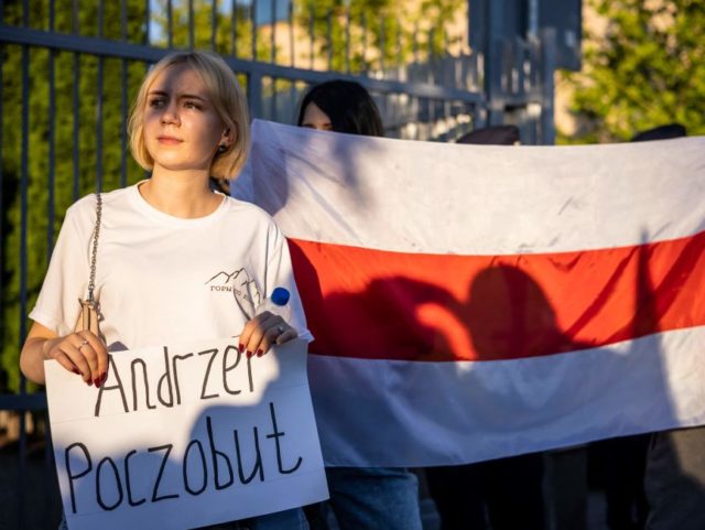 Activists and members of the Belarusian diaspora in Poland hold placards and former nation