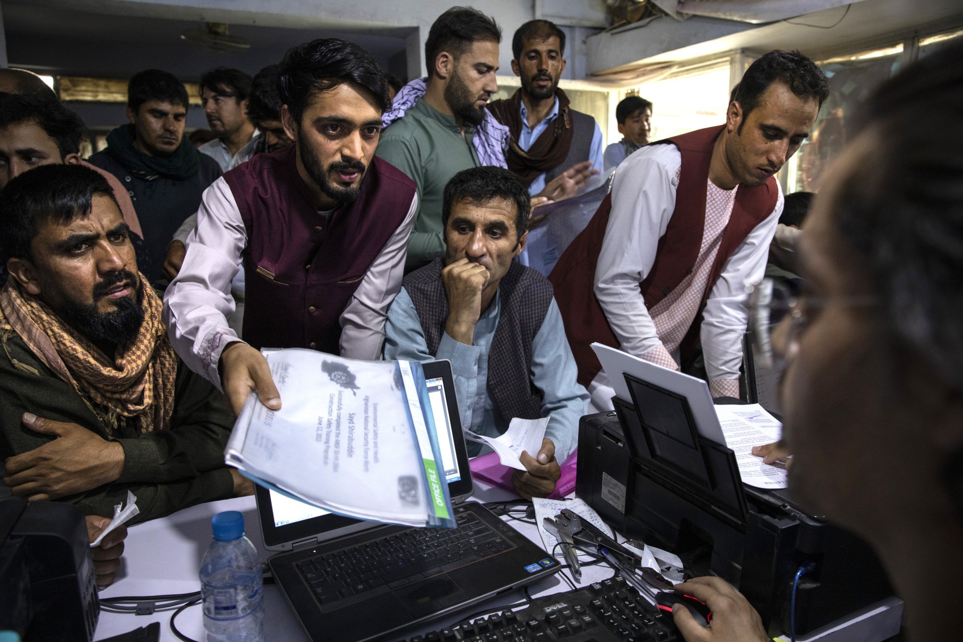 KABUL, AFGHANISTAN - AUGUST 8: Afghan Afghan Special Immigrant Visa (SIV) applicants crowd into the Herat Kabul Internet cafe seeking help applying for the SIV program on August 8, 2021 in Kabul, Afghanistan. Many Afghans are in desperate need of assistance completing the forms and obtaining the required human resources letters, a particular challenge for those whose US government work ended years ago. The Biden administration expanded refugee eligibility for Afghans as the Taliban escalates violence in the war-torn country. Thousands of Afghans who worked for the United States government during its nearly 20-year war here now fear for their safety as the US withdraws its troops from the country. Many of these Afghans, who worked as interpreters and translators for US intelligence agencies and military branches, have applied to come to the US as part of the Special Immigrant Visa (SIV) program, with the first such group arriving in the US last month. But, for most SIV candidates, the timeline for relocation remains unknown. (Photo by Paula Bronstein/Getty Images)