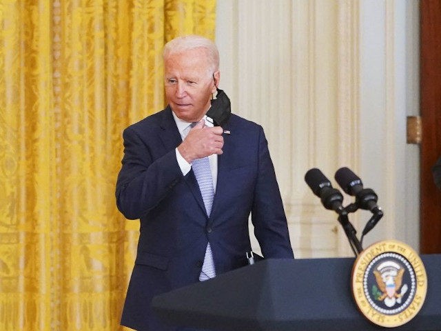 US President Joe Biden takes off his mask as he arrivers to speak on prescription drug pri