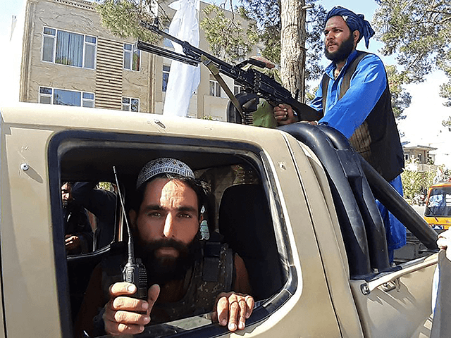 In this picture taken on August 13, 2021, Taliban fighters are pictured in a vehicle along the roadside in Herat, Afghanistan's third biggest city, after government forces pulled out the day before following weeks of being under siege. (Photo by - / AFP) (Photo by -/AFP via Getty Images)