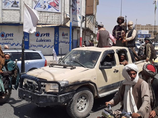 Taliban fighters drive an Afghan National Army (ANA) vehicle through a street in Kandahar on August 13, 2021. (Photo by - / AFP) (Photo by -/AFP via Getty Images)