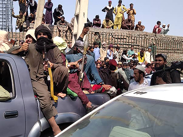 Taliban fighters sit on a vehicle along the street in Jalalabad province on August 15, 202