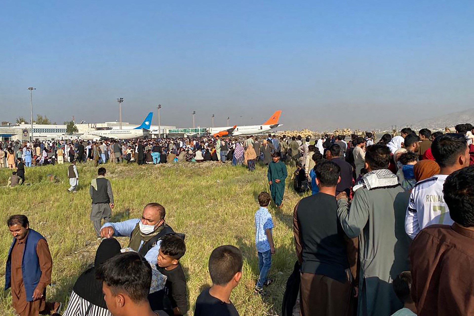 TOPSHOT - Afghans crowd at the airport as they wait to leave from Kabul on August 16, 2021. (Photo by Shakib Rahmani / AFP) (Photo by SHAKIB RAHMANI/AFP via Getty Images)