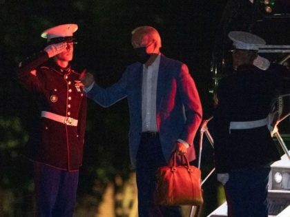 US President Joe Biden salutes as he disembarks from Marine One at Fort McNair upon return