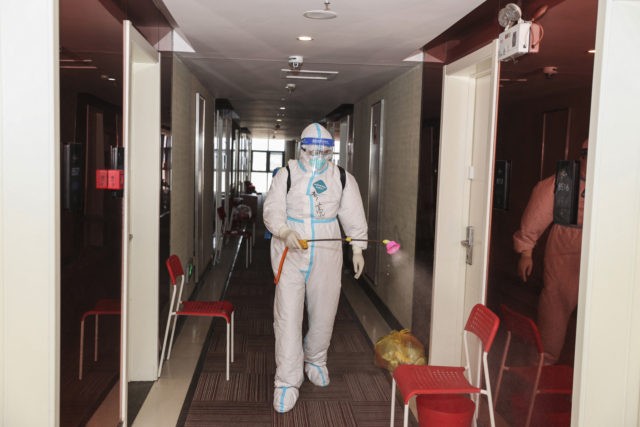 A medical staff member wearing personal protective equipment (PPE) against the spread of Covid-19 sprays disinfectant at a quarantine hotel in Lianyungang in China's eastern Jiangsu province on August 19, 2021. - China OUT (Photo by STR / AFP) / China OUT (Photo by STR/AFP via Getty Images)