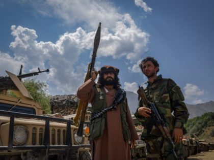 TOPSHOT - Afghan armed men supporting the Afghan security forces against the Taliban stand with their weapons and Humvee vehicles at Parakh area in Bazarak, Panjshir province on August 19, 2021. (Photo by Ahmad SAHEL ARMAN / AFP) (Photo by AHMAD SAHEL ARMAN/AFP via Getty Images)