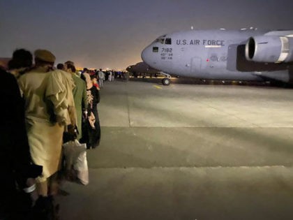 Afghan people queue up and board a U S military aircraft to leave Afghanistan, at the mili