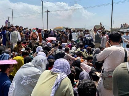 TOPSHOT - Afghan people gather along a road as they wait to board a U S military aircraft to leave the country, at a military airport in Kabul on August 20, 2021 days after Taliban's military takeover of Afghanistan. (Photo by Wakil KOHSAR / AFP) (Photo by WAKIL KOHSAR/AFP via …