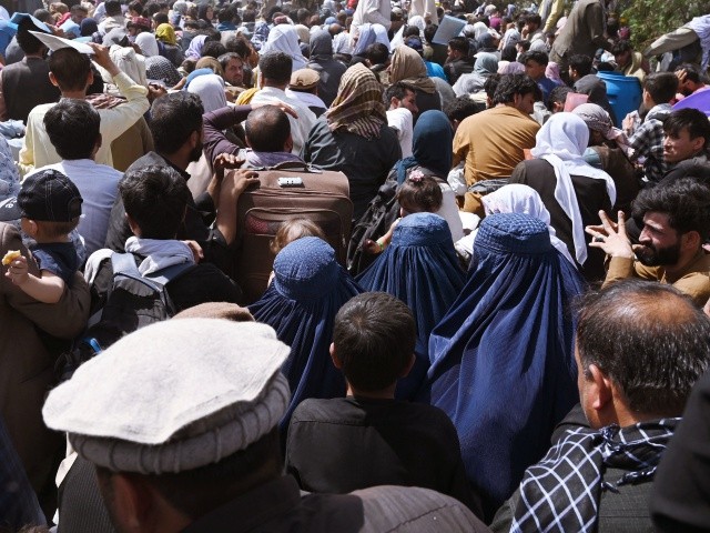 Afghans gather on a roadside near the military part of the airport in Kabul on August 20, 2021, hoping to flee from the country after the Taliban's military takeover of Afghanistan. (Photo by Wakil KOHSAR / AFP) (Photo by WAKIL KOHSAR/AFP via Getty Images)