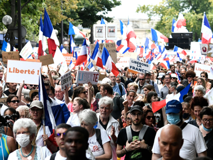 Protesters wave French flags and hold banners reading "freedom" as they march during a nat