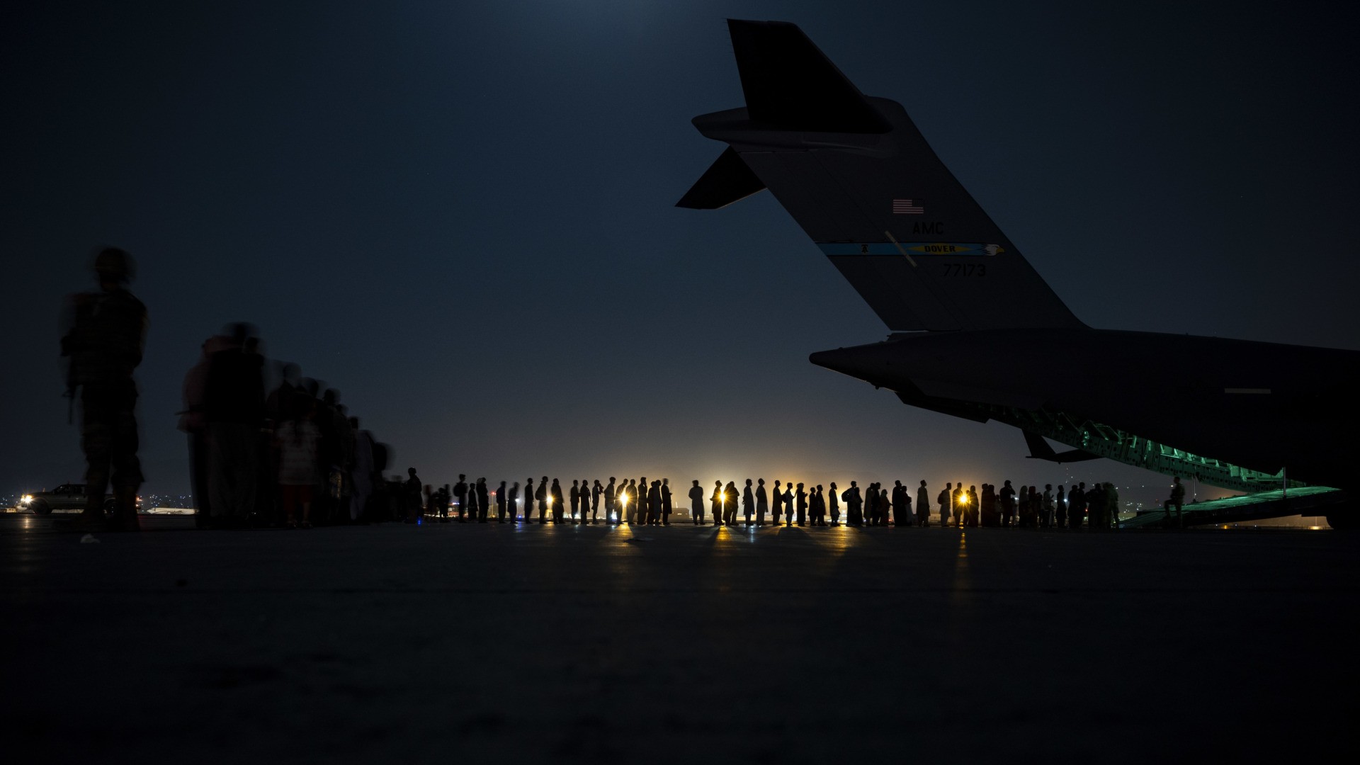 KABUL, AFGHANISTAN - AUGUST 21: In this handout provided by the U.S. Air Force, an air crew prepares to load evacuees aboard a C-17 Globemaster III aircraft in support of the Afghanistan evacuation at Hamid Karzai International Airport on August 21, 2021 in Kabul, Afghanistan. (Photo by Taylor Crul/U.S. Air Force via Getty Images)