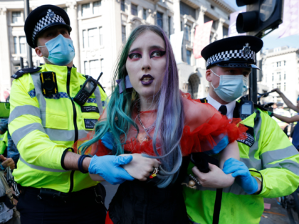 Police officers take away a climate activist from the Extinction Rebellion group during th