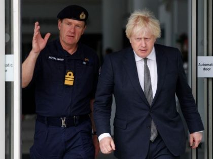 Britain's Prime Minister Boris Johnson (R) walks with Vice Admiral Ben Key (L) as he